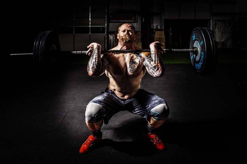 man strength training with barbell
