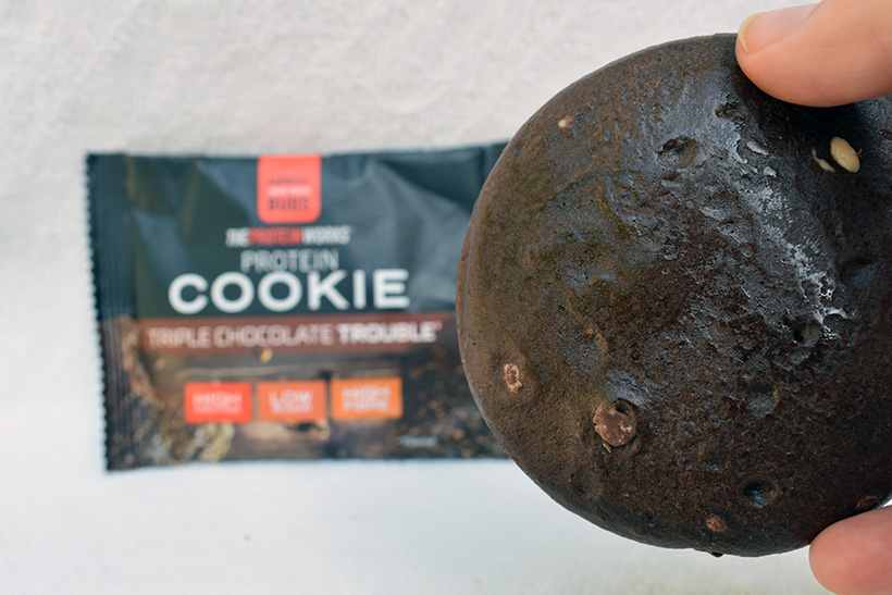 The protein works protein snacks Protein cookie triple chocolate trouble Flavour packaging with close up cookie